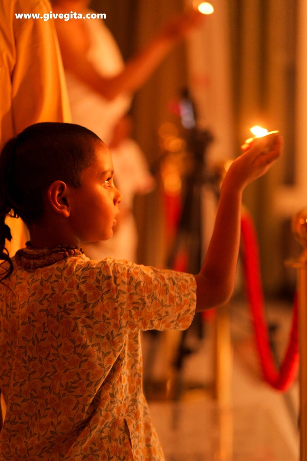 Lord Damodar with a lamp offering